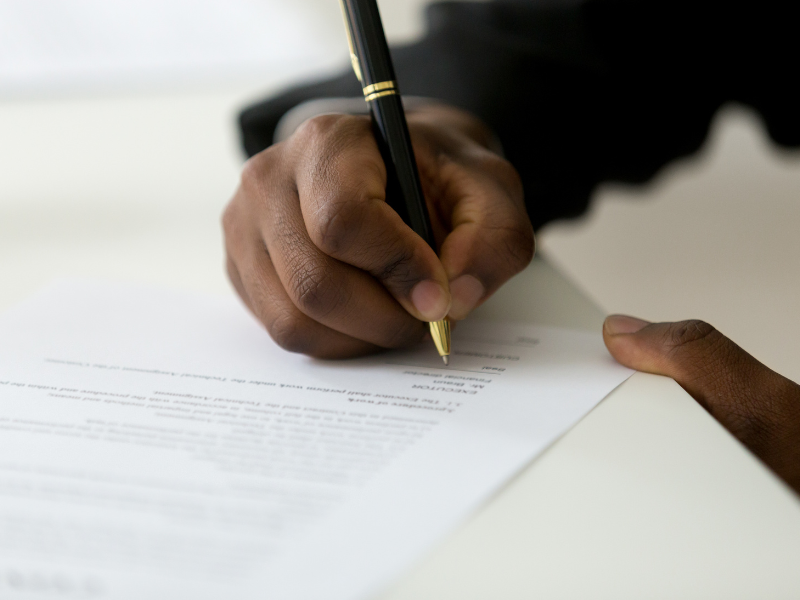 Close up of a man’s hand signing a stat dec