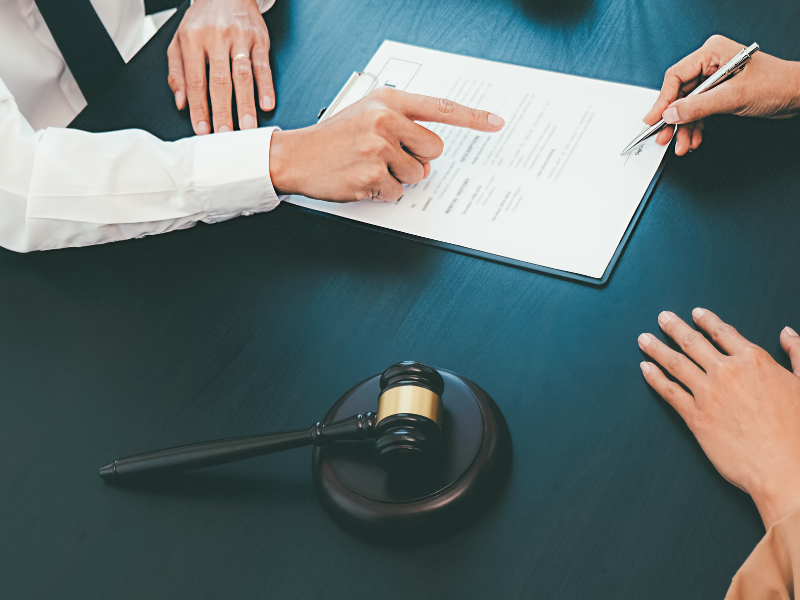 A person signing a stat dec in front of a witness, a judge’s gavel on the table