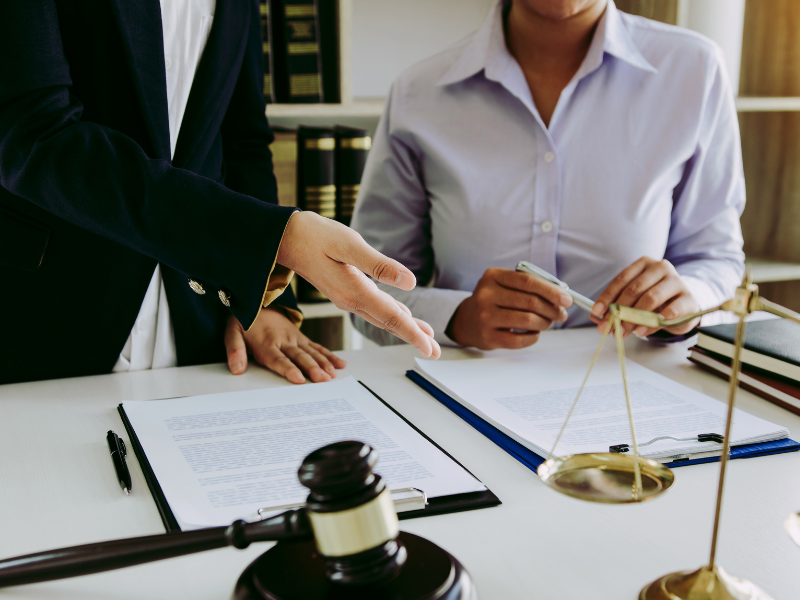 A person making a stat dec with a witness, a judge’s gavel and law scales on the table