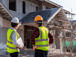 Contractors or builders in safety gear examine an ongoing build