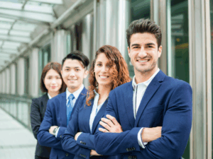 Four professionals in suits line up with their arms crossed and smiling at the camera