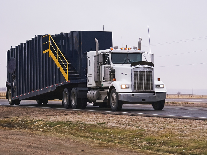 A white and blue large freight truck driving down the road