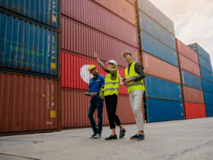Workers for a goods supplier surveying container trucks containing their product