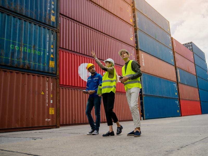 Workers for a goods supplier surveying container trucks containing their product