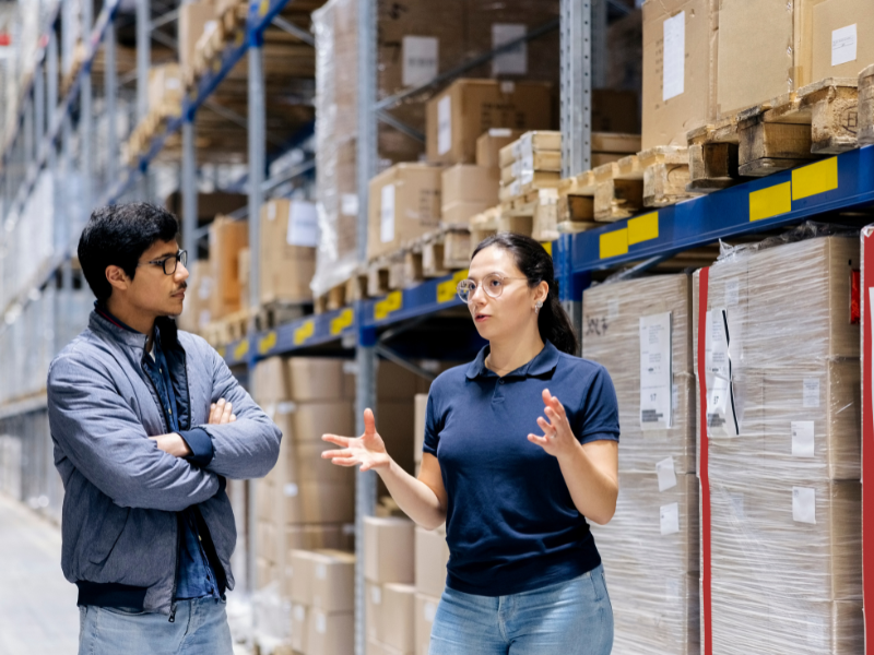 Representatives for a supplier and a retailer meeting inside a warehouse