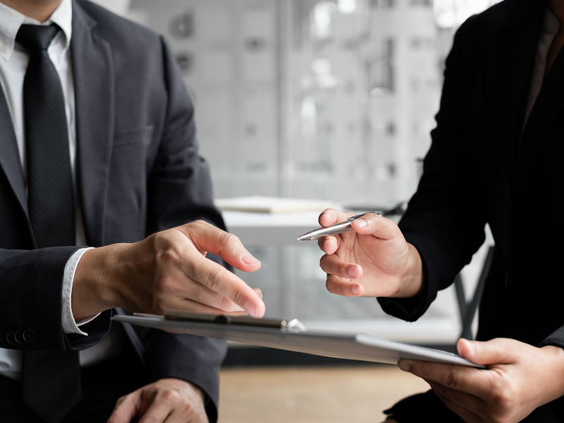 Cropped photo of two men discussing a document, a mortgage broker and a business owner discussing a commercial loan