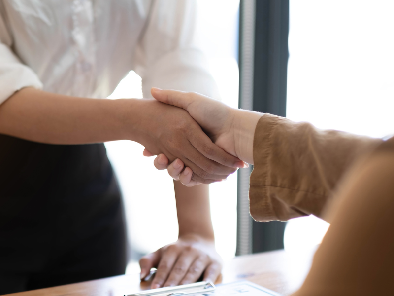 Cropped photo of two people shaking hands in a business setting, business owner and mortgage broker agreeing on a commercial loan solution