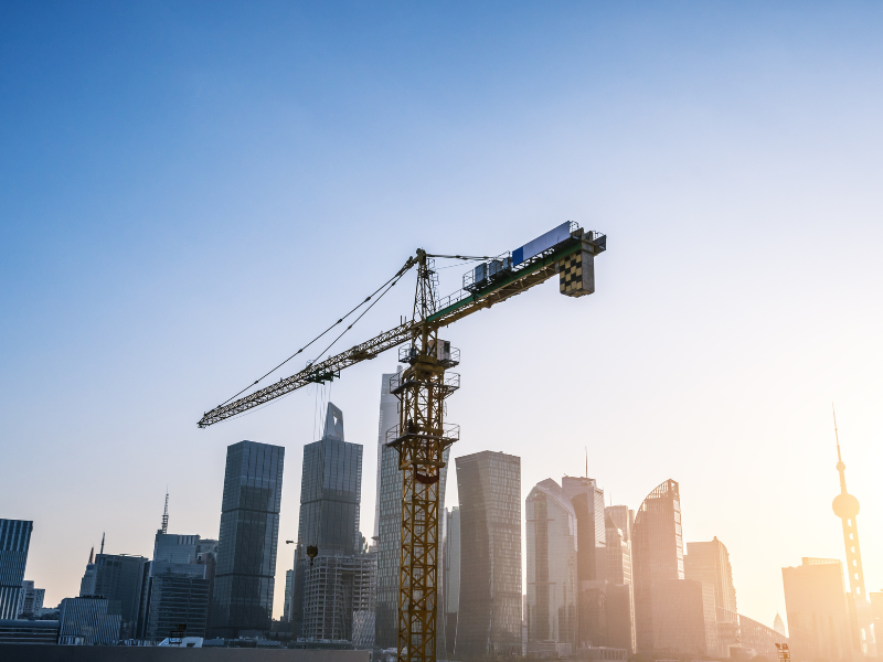 A large yellow crane, a cityscape in the background