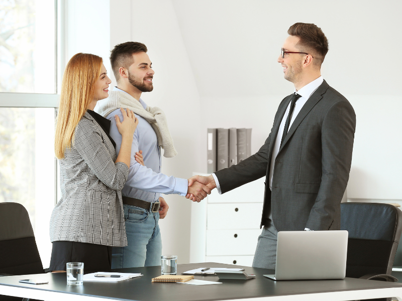 Business owners shake hands with a mortgage broker after agreeing on a working capital loan solution