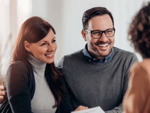 A business owning couple happily meet with a mortgage broker to apply for a commercial loan