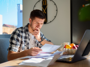 A man reads documents, a business owner considering an emergency loan