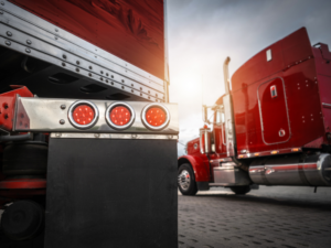 Back view, low angle photo of large red freight transport trucks