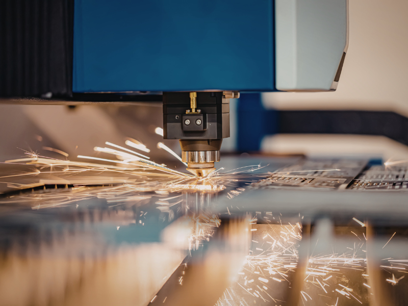 A metal fabrication machine sparks as it works on metal