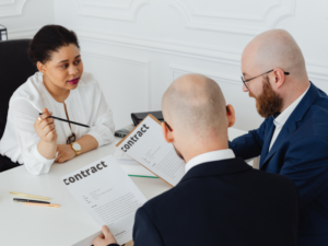 A mortgage broker presents emergency loan contracts to business owners