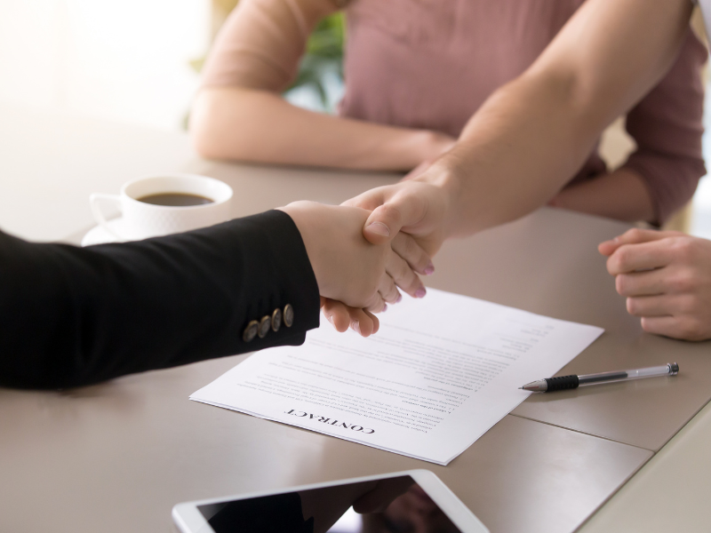 Cropped photo of a business owner shaking hands with a mortgage broker, agreeing to an emergency loan