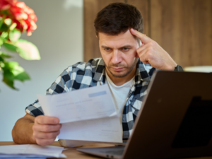 A stressed man reading a garnishee notice sent to him by the ATO