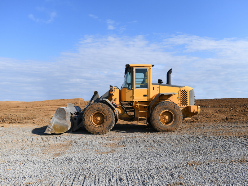 A small yellow bulldozer at a construction site