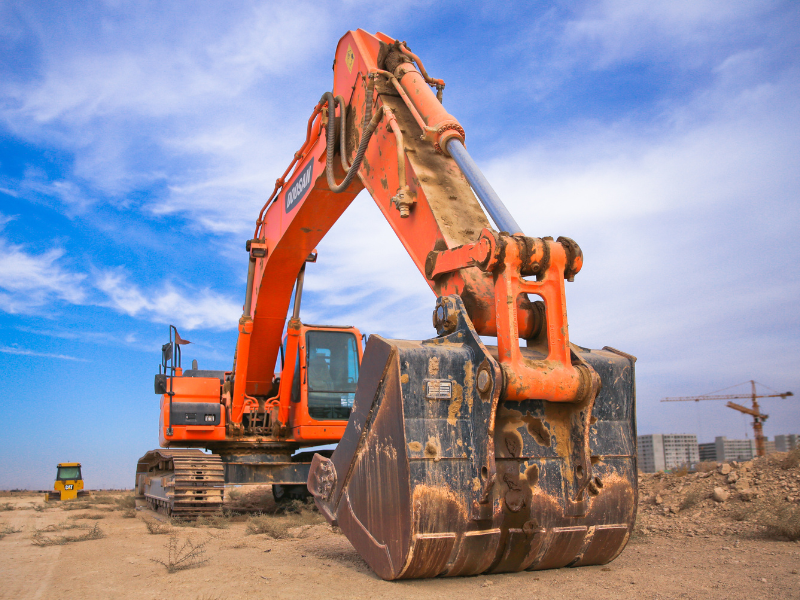 A large orange excavator at a construction site