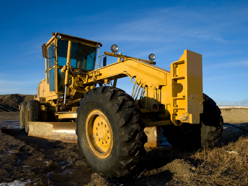 Yellow construction equipment with blue skies in the background