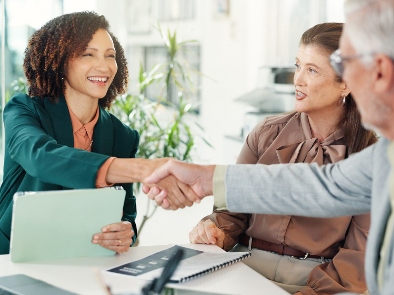 A mortgage broker shakes hands with a business owner after agreeing on a debt consolidation solution