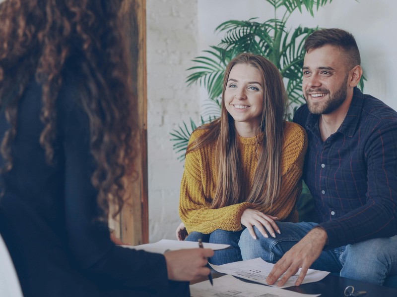 A business owning couple meets with a mortgage broker to talk about tax debt loans and consolidation