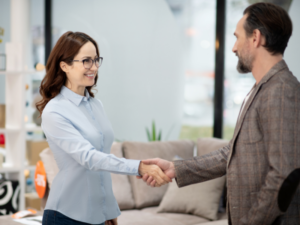 A man and a woman in a business setting shake hands