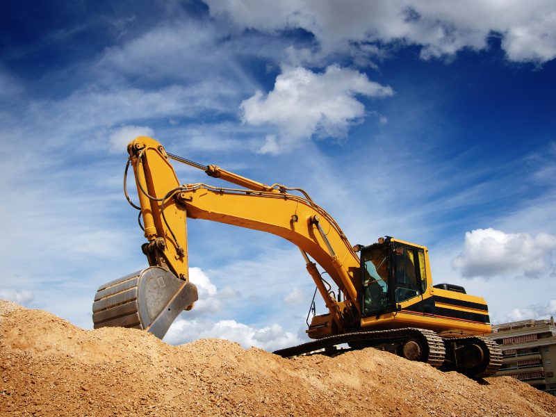 A yellow excavator digging dirt at a construction site