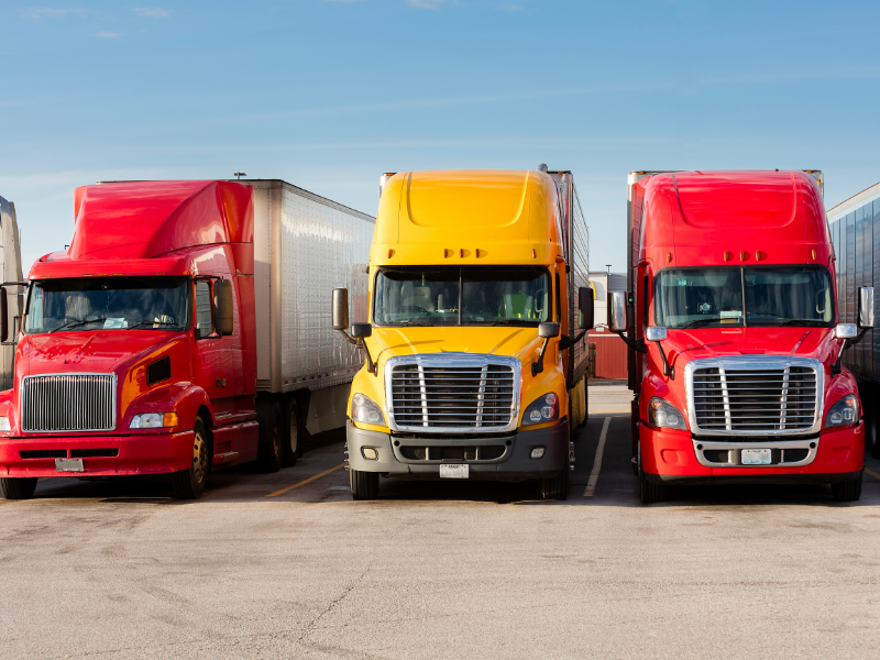 Three freight trucks parked next to each other