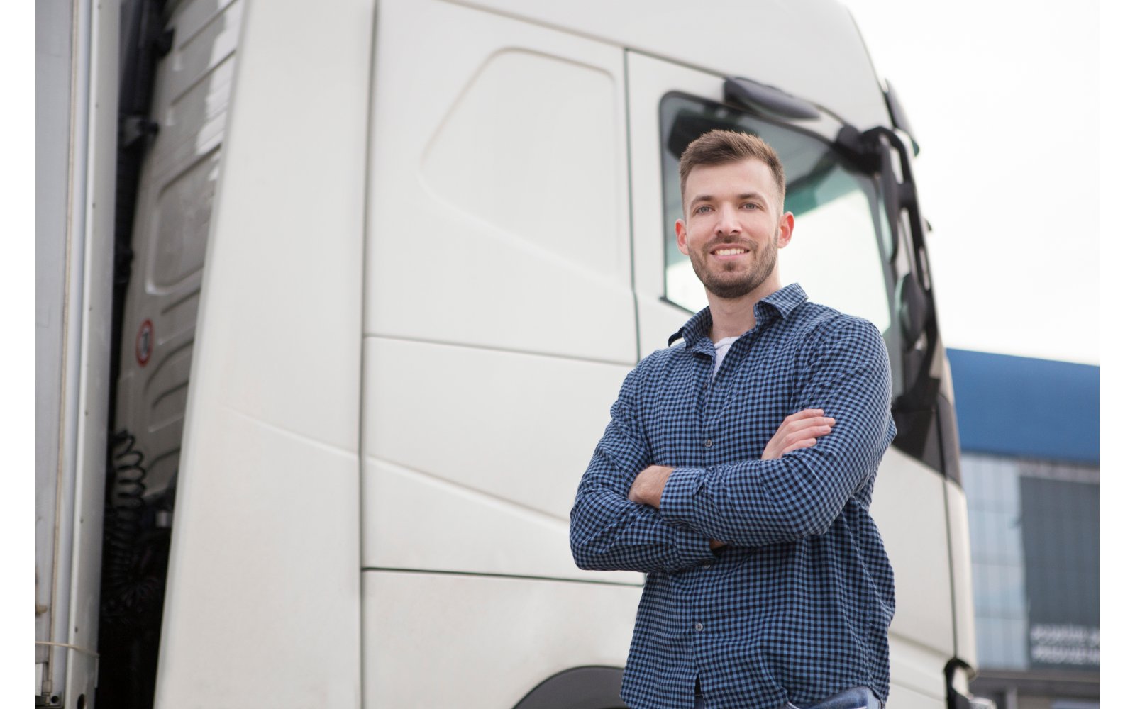 Transport business owner standing in front of his truck, offering the vehicle as security for an asset-based loan